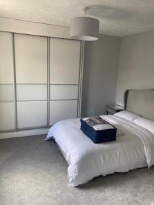 Un dormitorio con una cama con una maleta azul. en Huddersfield 2 bedroom house en Huddersfield