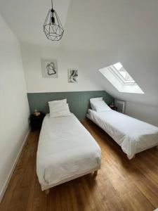 タンテニアックにあるMaison cosy 4 Personnesのベッドルーム1室(ベッド2台、天窓付)