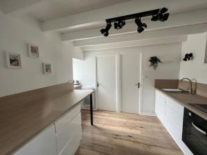 タンテニアックにあるMaison cosy 4 Personnesの白いキャビネットとカウンタートップを備えたキッチン