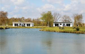 a couple of white buildings next to a lake at Beautiful Home In Ringkbing With 2 Bedrooms And Wifi in Hee