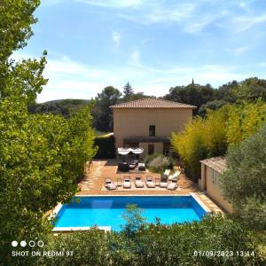 a swimming pool in front of a house at Villa La Charmeuse Fleurie in Collias