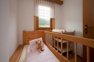 a teddy bear sitting on a bed in a bedroom at Gourmetbauernhof Mentebauer in Gmünd in Kärnten