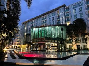 a building with a glass facade with a fountain in front at City Center Residence & Hot Hot Hot in Pattaya Central