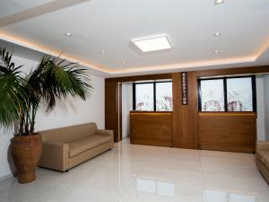 a lobby with a couch and a door and a plant at Pela Maria Hotel in Hersonissos