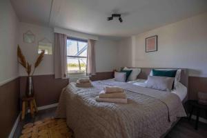 1 dormitorio con 1 cama grande y toallas. en Bed & outdoor wellness - natuurhuisje Oisterwijk en Oisterwijk