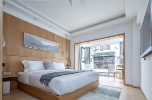ein Schlafzimmer mit einem großen Bett und einem großen Fenster in der Unterkunft Guilin Bonjour Boutique Hotel in Guilin