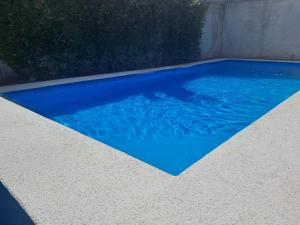 einen Pool mit blauem Wasser im Hinterhof in der Unterkunft Cabina Privada en Segundo piso con piscina, a 2 min caminando de la playa in Brasilito