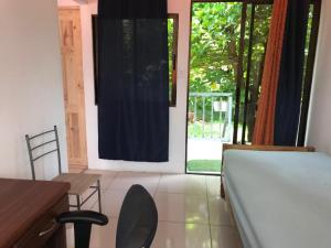 1 dormitorio con 1 cama, mesa y sillas en Cabina Privada en Segundo piso con piscina, a 2 min caminando de la playa, en Brasilito