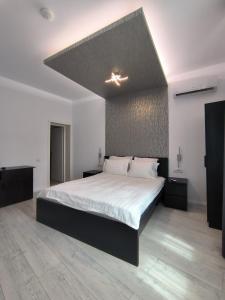 una camera da letto con un grande letto con lenzuola bianche di Romana Residence a Bucarest