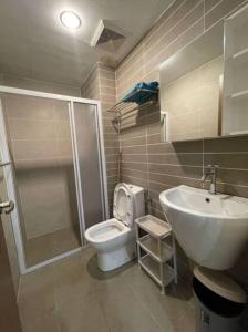 uma casa de banho com um chuveiro, um WC e um lavatório. em Infinity Pool at Kozi Square Homestay em Kuching