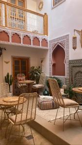 een patio met stoelen en tafels en een balkon bij RIAD LA LUNE in Marrakesh