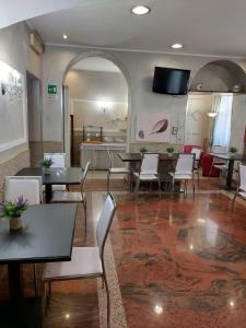 una sala da pranzo con tavoli e sedie bianche di Appartamenti Valdocco a Torino