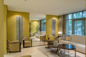 a waiting room with couches and tables and windows at Vivienda Hotel Villas Granada in Riyadh