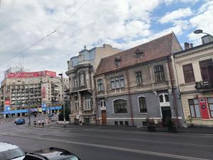 una calle de la ciudad con edificios y una calle con coches en Romana Residence, en Bucarest