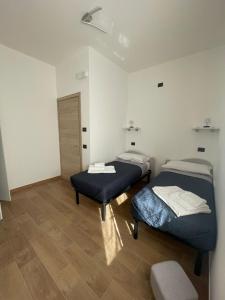 two twin beds in a room with wooden floors at Civico 185 in Acri