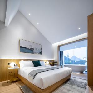 a bedroom with a large bed and a large window at Guilin Bonjour Boutique Hotel in Guilin