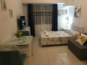 Cette petite chambre comprend un lit et une télévision. dans l'établissement Alex apartment Horizon 101, à Cebu 28 autres photos