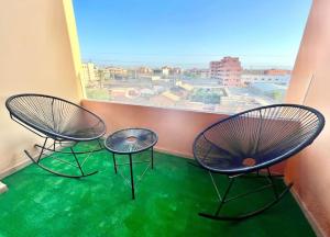 - un balcon avec une fenêtre doté de 2 chaises et d'une table dans l'établissement Cozy&Elegant apartment/pool/city center/Gueliz, à Marrakech