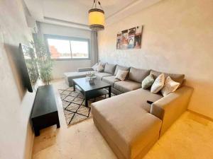 - un salon avec un canapé et une table dans l'établissement Cozy&Elegant apartment/pool/city center/Gueliz, à Marrakech
