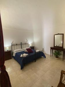 1 dormitorio con cama y espejo en Rinaldo Holiday Home, en Sambuca di Sicilia
