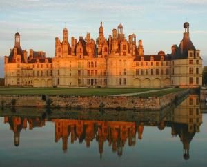 um grande castelo com o seu reflexo na água em Le chaleureux. Maison à 2 pas du centre ville/proche du zoo de Beauval em Contres
