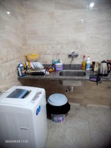 a bathroom with a sink and a washing machine at Down town new El alamein in El Alamein