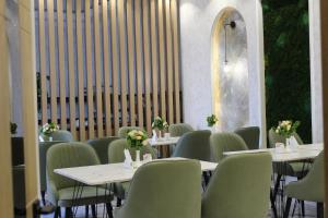 a restaurant with tables and chairs with flowers on them at Modern Hotel in Tashkent