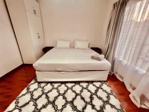 a small bedroom with two beds and a rug at Mont Pelaan 40 in Newcastle
