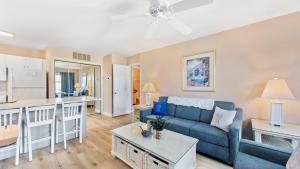 a living room with a blue couch and a kitchen at Lighthouse Point Villas in Ocean City