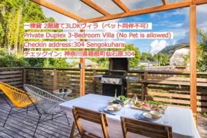 eine Terrasse mit einem Tisch, Stühlen und einem Grill in der Unterkunft SPRINGS VILLAGE HAKONE Glamping Resort in Hakone