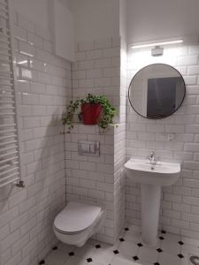 a white bathroom with a toilet and a sink at Urban Nest Apartments Starowiślna 30A in Krakow