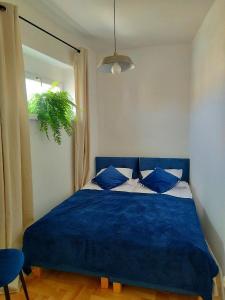 a blue bed with blue pillows in a bedroom at Urban Nest Apartments Starowiślna 30A in Krakow