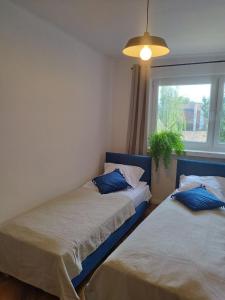 two beds in a room with a window at Urban Nest Apartments Starowiślna 30A in Krakow