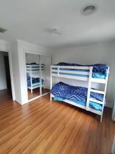 2 literas en una habitación con suelo de madera en 5 bedroom home in a quiet area en Mill Park