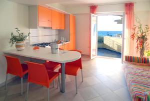 a kitchen with a table and chairs and a view of the ocean at La Baia Di Ulisse in Venetico