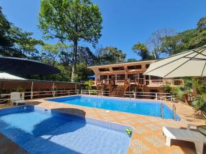 a swimming pool in front of a house at Cool Waters Jungle Villas in Uvita