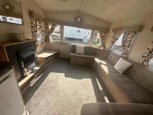 a living room with a couch and a fireplace at Caravan Delta 2 Bedroom in Rhyl in Rhyl