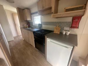 a small kitchen with a black stove top oven at Caravan Delta 2 Bedroom in Rhyl in Rhyl