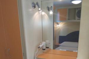 a bathroom with a mirror and a bed in a room at Holiday Travel Genius at Toscana Holiday Village Camping in San Romano