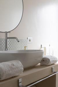 bagno con lavandino e specchio di Oronti Accommodations a Lecce