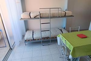 a room with two bunk beds and a table at Studio maison de la mer in Saint Pierre La Mer