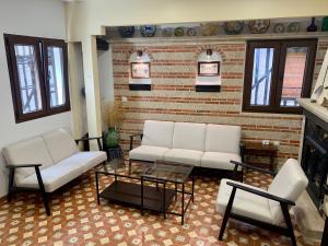 a living room with two white couches and a coffee table at Casa Rural Chorrito 1 in La Alberca