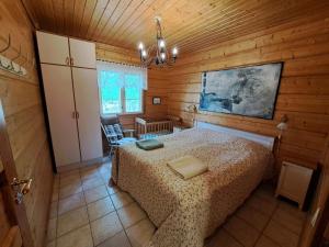 sypialnia z łóżkiem w drewnianym pokoju w obiekcie Kurkimökki w mieście Parikkala