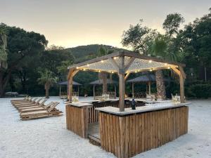 a pavilion with a bar with lights on a beach at Domaine de Miremer in La Garde-Freinet