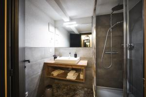 un bagno con lavandino e doccia di Berghotel Basur - Das Schihotel am Arlberg a Flirsch Altre 37 foto