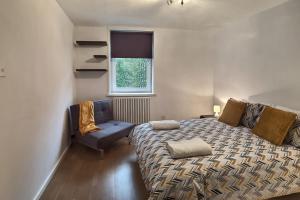 a bedroom with a bed and a chair and a window at Regents Park Area in London