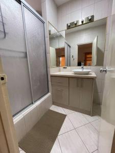 bagno con doccia, lavandino e specchio di Departamento en kennedy amplio para familia a Guayaquil
