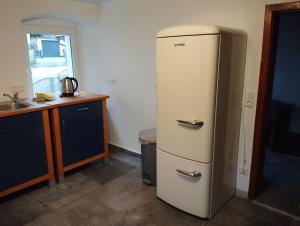 a white refrigerator in a kitchen with a sink at Monteurhaus Mühlbach :-) in Stadtsteinach