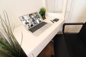 einen weißen Schreibtisch mit einem Laptop darüber in der Unterkunft Downtown Apartments Ulm - im Herzen von Ulm & komfortable Boxspringbetten in Ulm