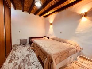 a bedroom with a bed and a tv in it at Tikay Humahuaca Refugio de Tierras in Humahuaca